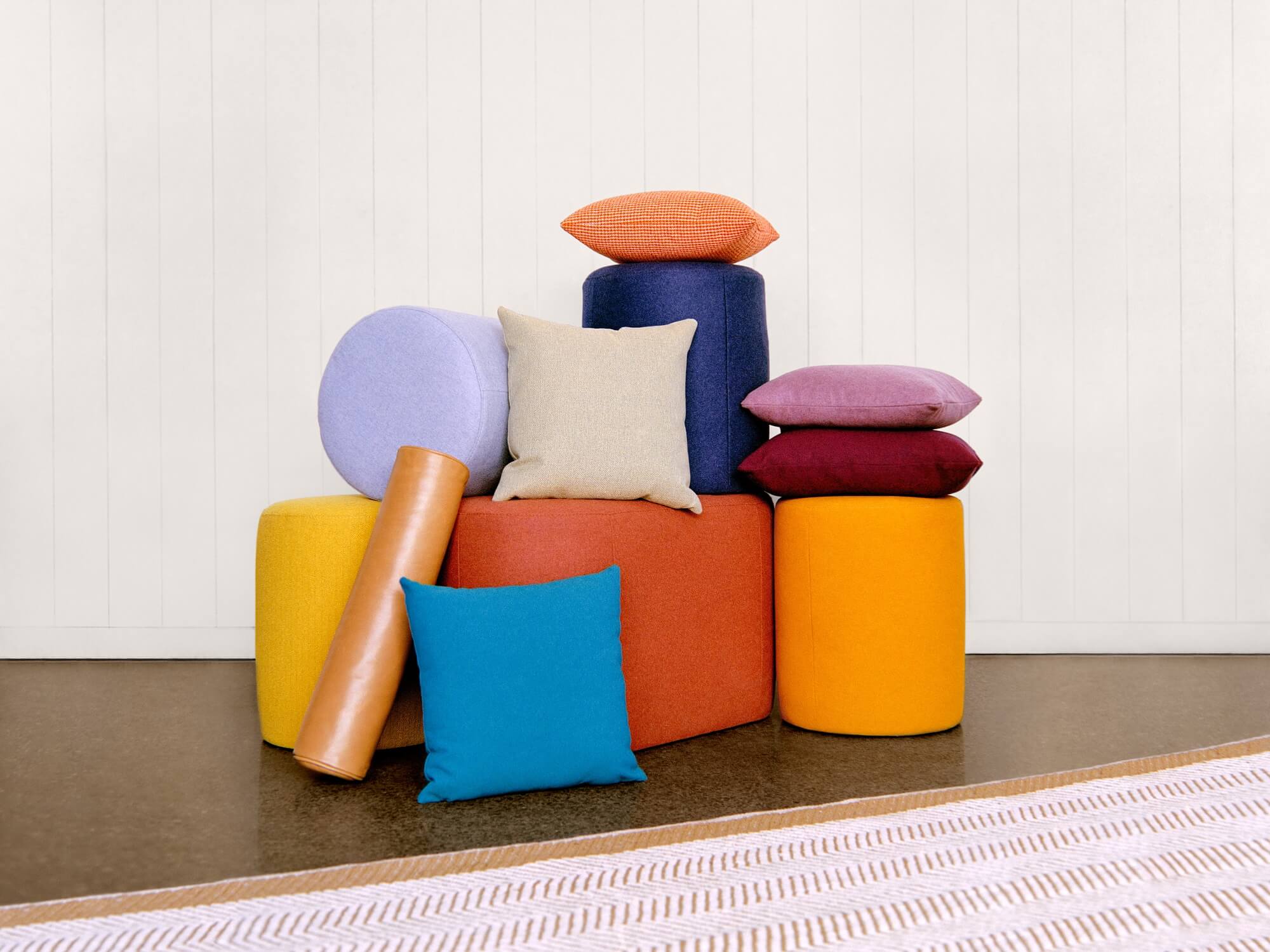 Rainbow colored accent pillows with ottomans in different shapes